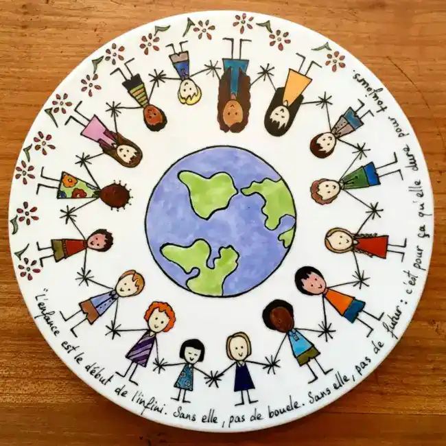 Petit dessous de plat rond personnalisé par une farandole d'enfants autour de la terre et par une citation