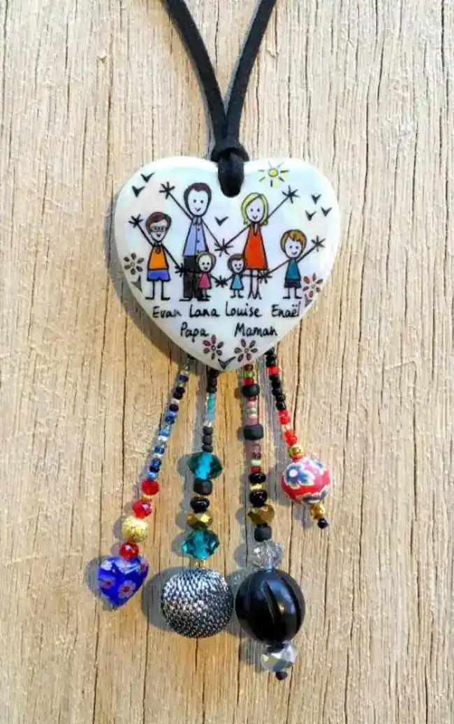 Pendentif cœur en porcelaine et breloques personnalisé dans un style naïf fond nacré.