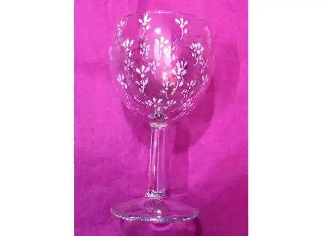 Verre à vin forme ballon personnalisé par des petites fleurs blanches.