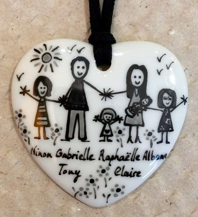 Pendentif coeur en porcelaine personnalisé dans un style naïf en noir et gris.